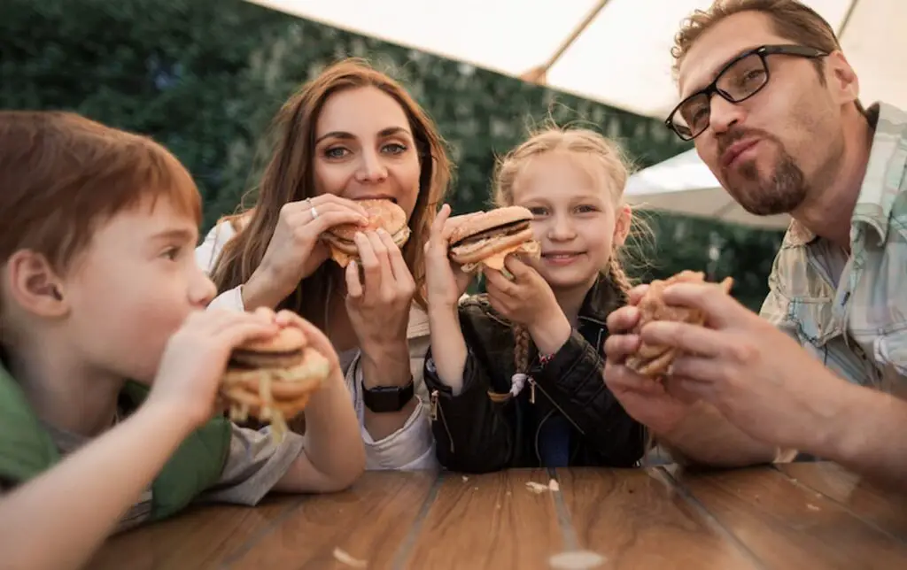 Family eating burgers together in a restaurant